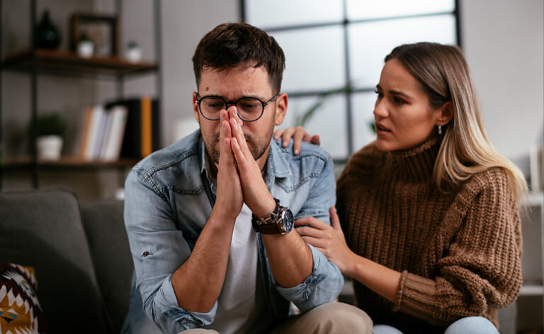 Wife comforting her husband who is struggling with symptoms of depression