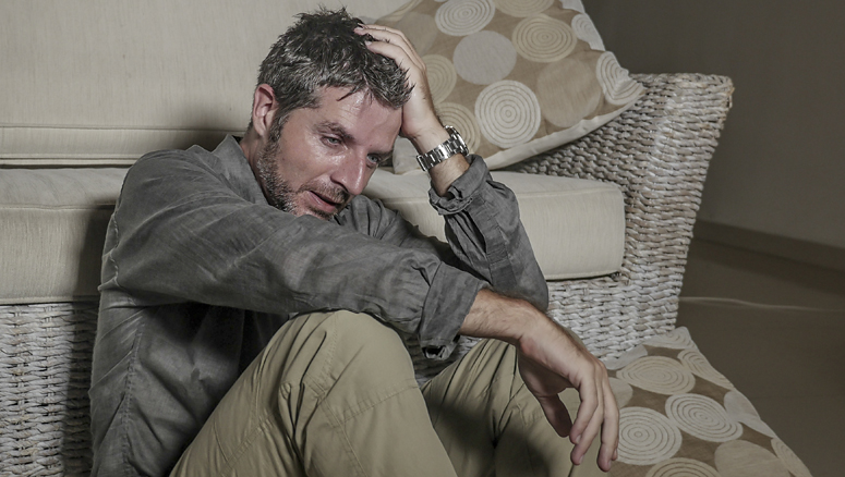 Depressed man sat on floor