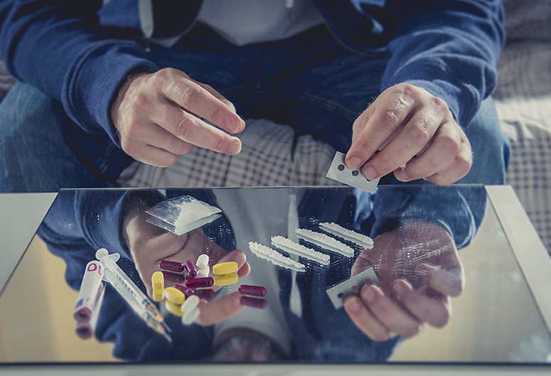 Addict preparing drugs on a mirror