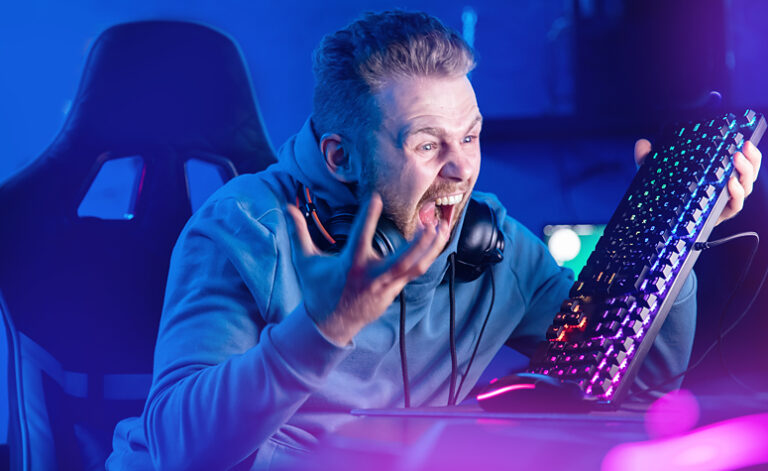 Angry man frustrated at losing an online game, demonstrating symptoms of gaming addiction