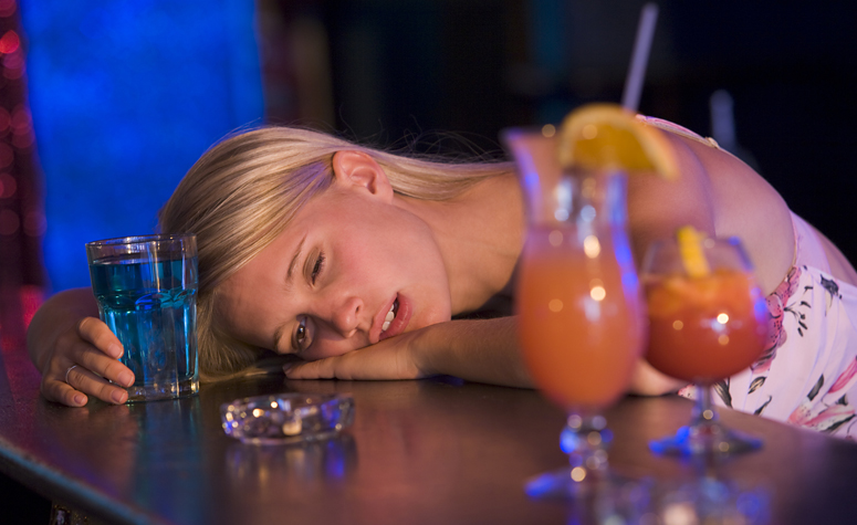 Young girl at the bar, drunk after binge drinking