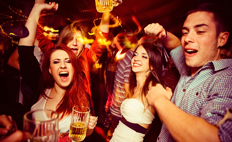 Group of young people out enjoying the night club scene drinking alcohol and partying