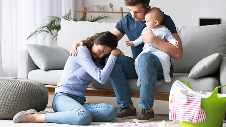 Woman struggling with postpartum been comforted by her supporting husband