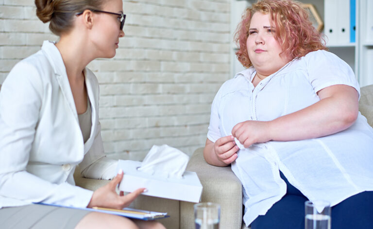 Large woman receiving eating disorder therapy treatment at AddictionRehab