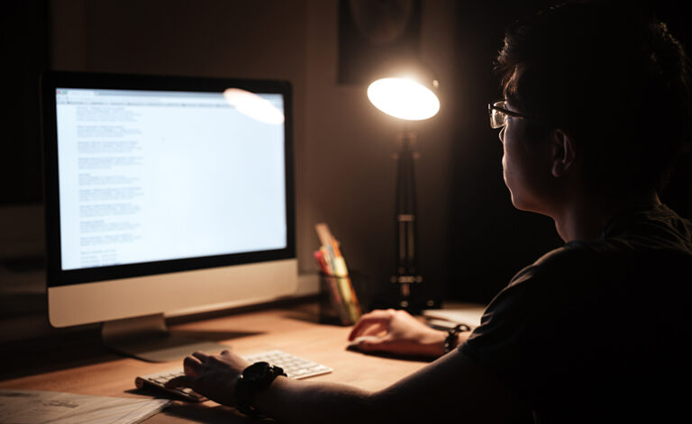 Man surfing the internet late at night suffering from internet addiction problems