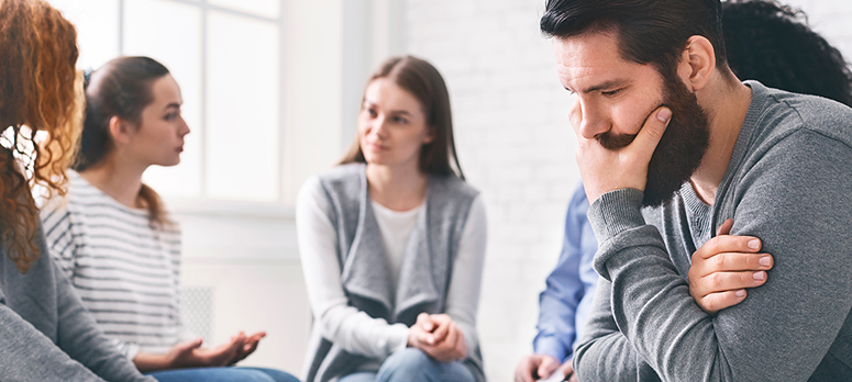 Anxious man in group therapy at addiction rehab