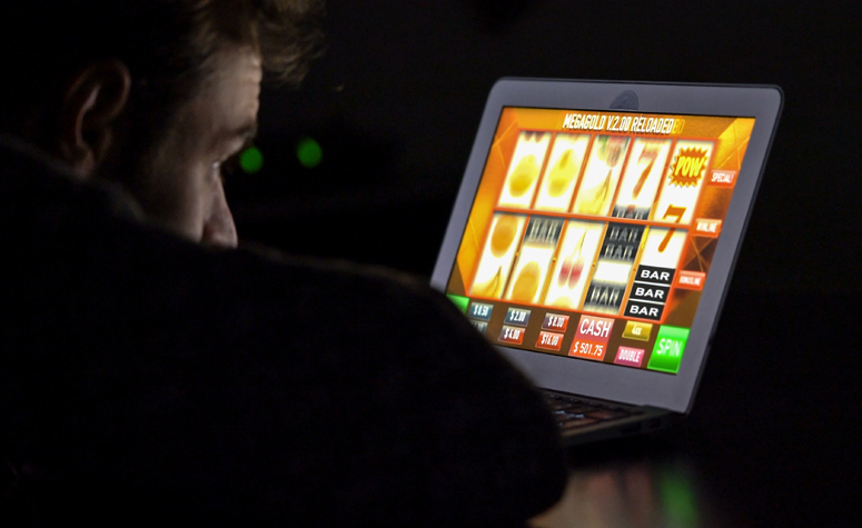 Man with gambling addiction playing online fruit machines
