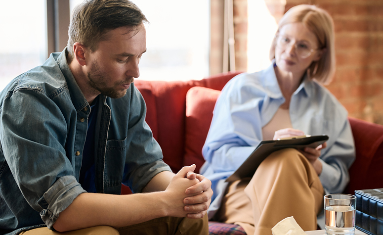 Man sat with therapist during his addiction rehab treatment