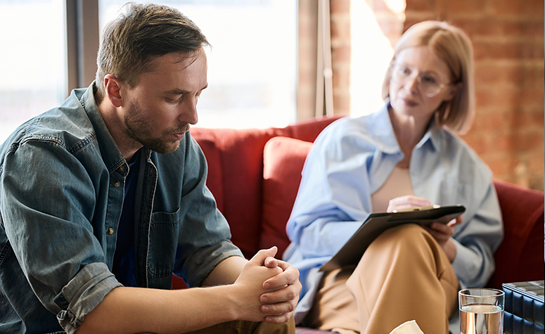 Man receiving diagnosis from therapist for his addictive behaviour
