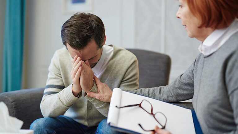 Man suffering with anxiety in therapy session with psychiatrist