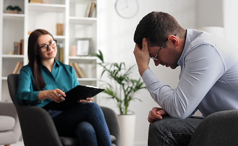 Psychologist taking patient notes at rehab detox clinic