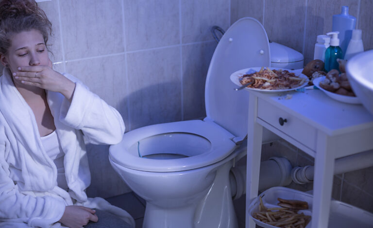 Woman in bathroom suffering from an eating disorder