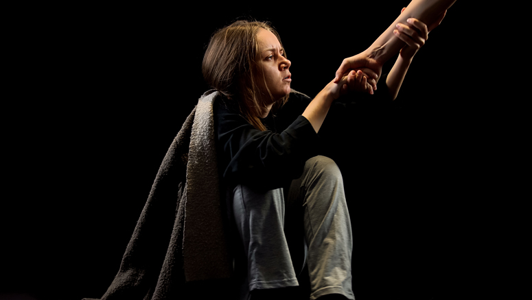 Addicted woman reached out and grasping the hand of help