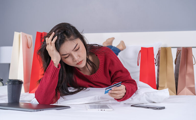Woman worrying about her financial situation after going on yet another shopping addiction spree