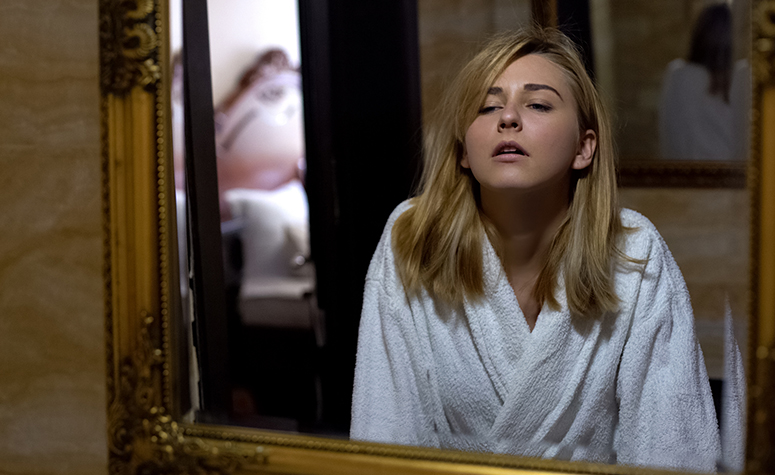 Women suffering from alcoholic hangover looking in the mirror