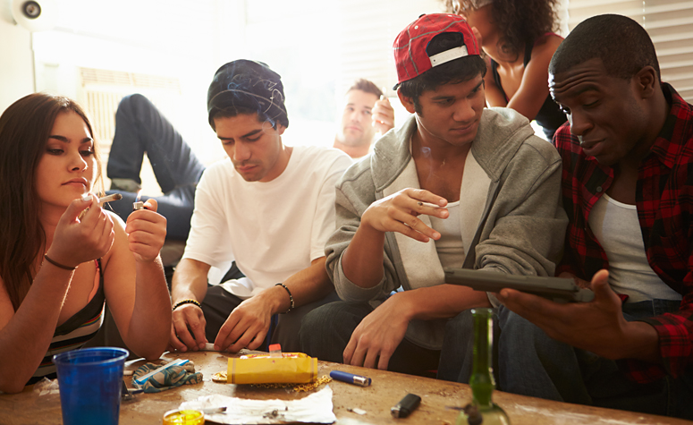 Young group of people enjoying a party taking drugs and drinking alcohol