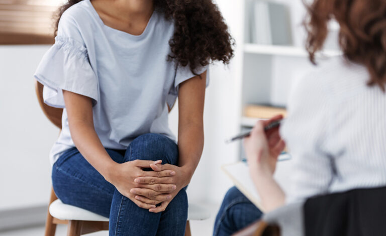 Young woman in counselling and therapy session discussing her eating disorder and anorexia