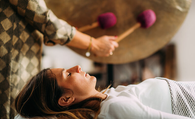 Lady participating in gong therapy as part of her recovery treatment plan