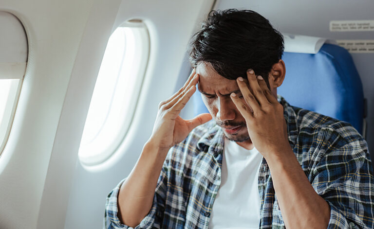 Man with agoraphobia sat on plane experiencing heightened anxiety