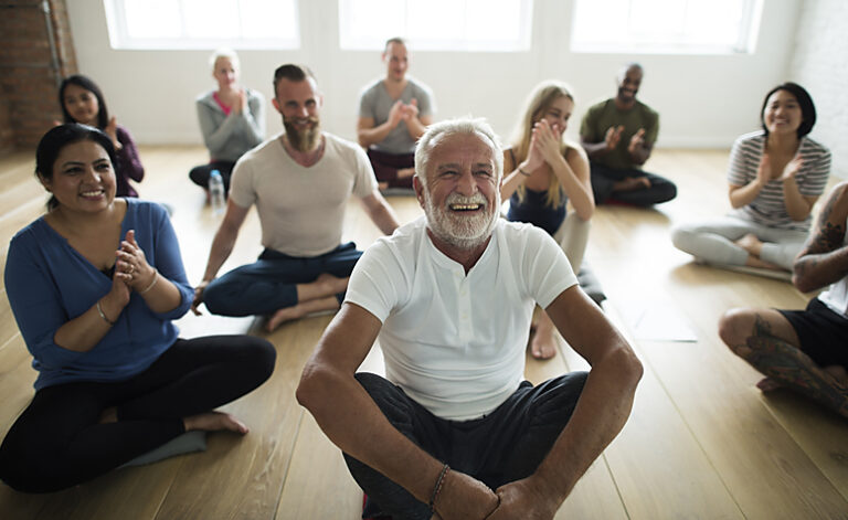 Group of recovering addicts taking part in holistic group yoga session