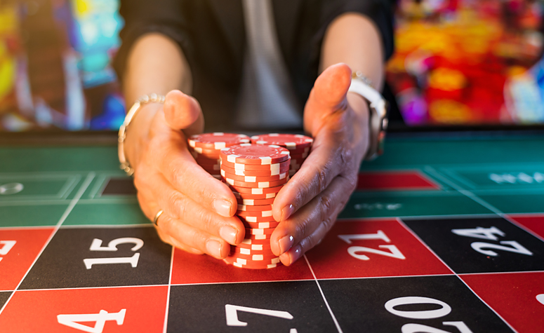 Croupier placing poker chips on table at a casino