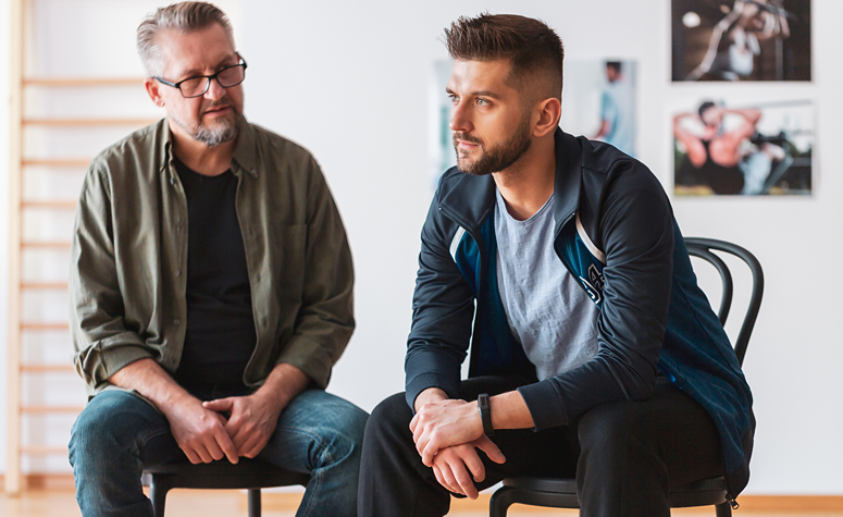 Man sat with talking with an addiction therapist during his cocaine treatment programme