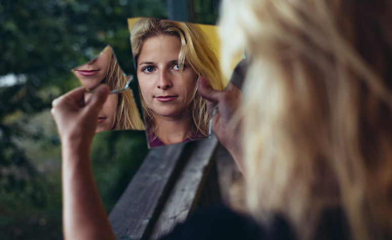 Schizophrenic woman looking in mirror