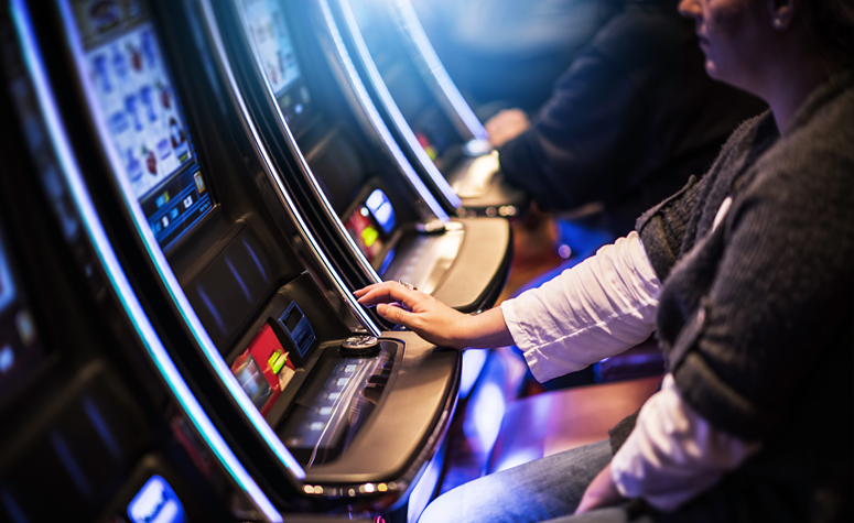 Woman with a gambling problem playing on fruit machines