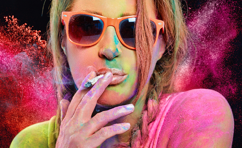 Woman smoking cannabis covered in colour paint dust