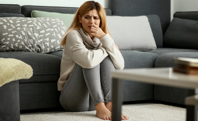 Woman suffering with dry drunk syndrome sat on the floor full of anxiety