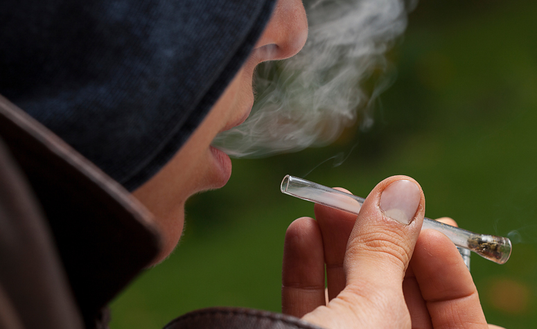 Man smoking crack cocaine with pipe