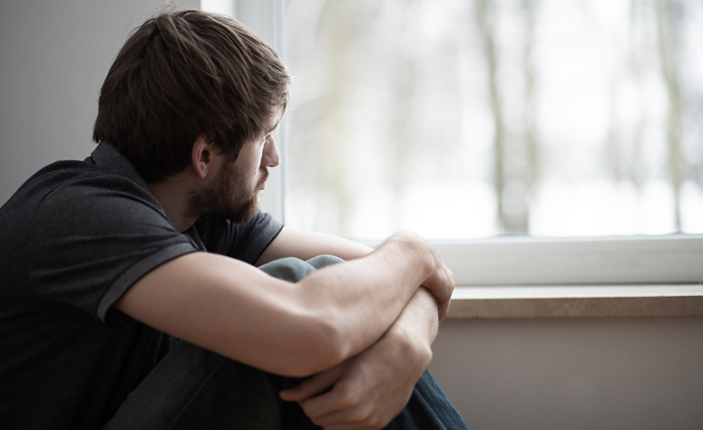 Man suffering with depression and other symptoms of trauma