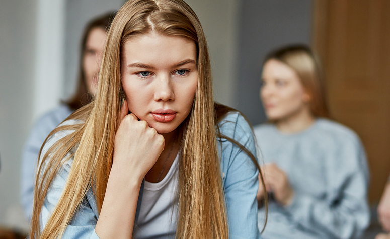 Socially anxious woman suffering with symptoms whilst in a group of other people